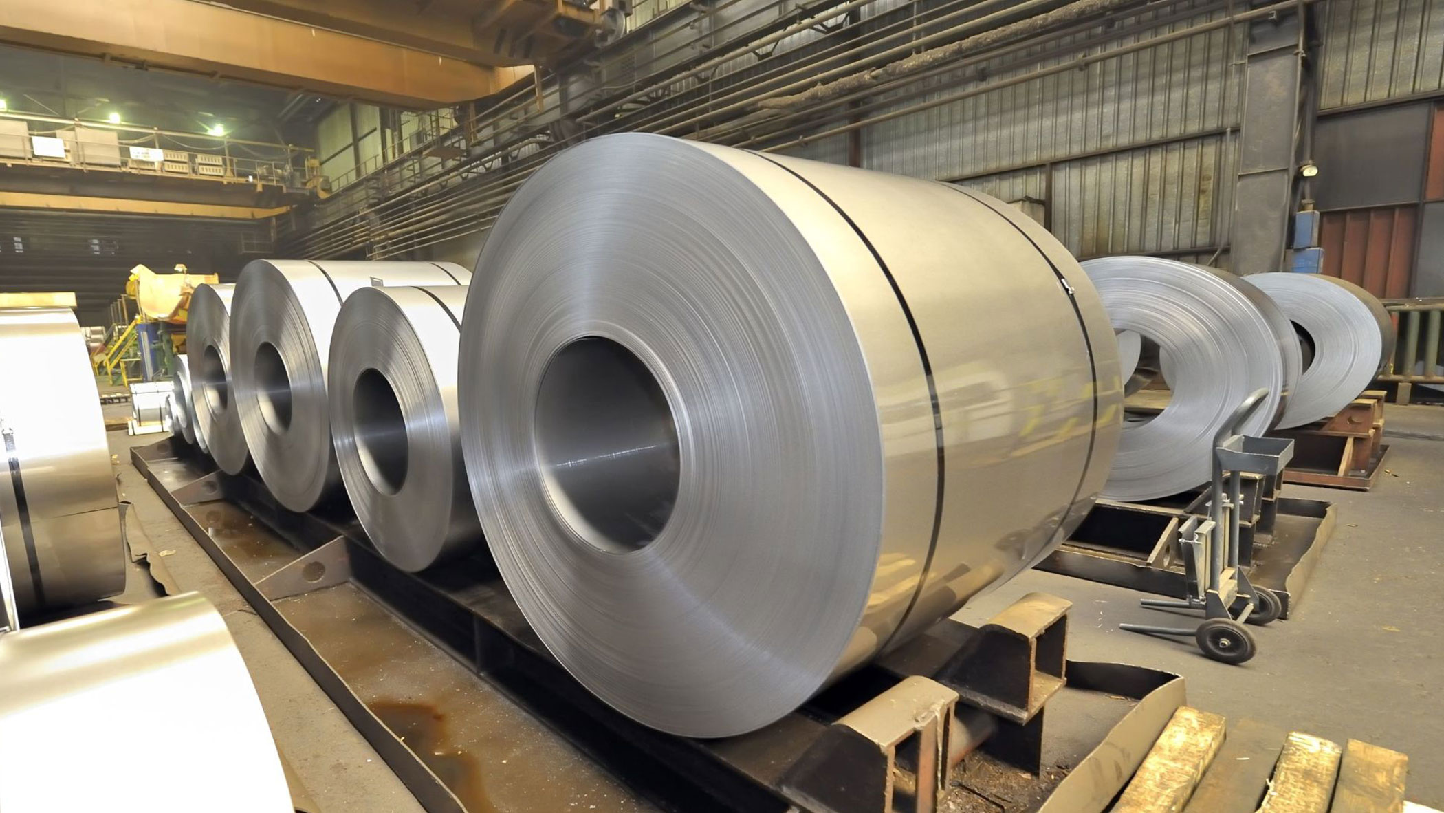 Giant steel coils sitting in a line in a warehouse